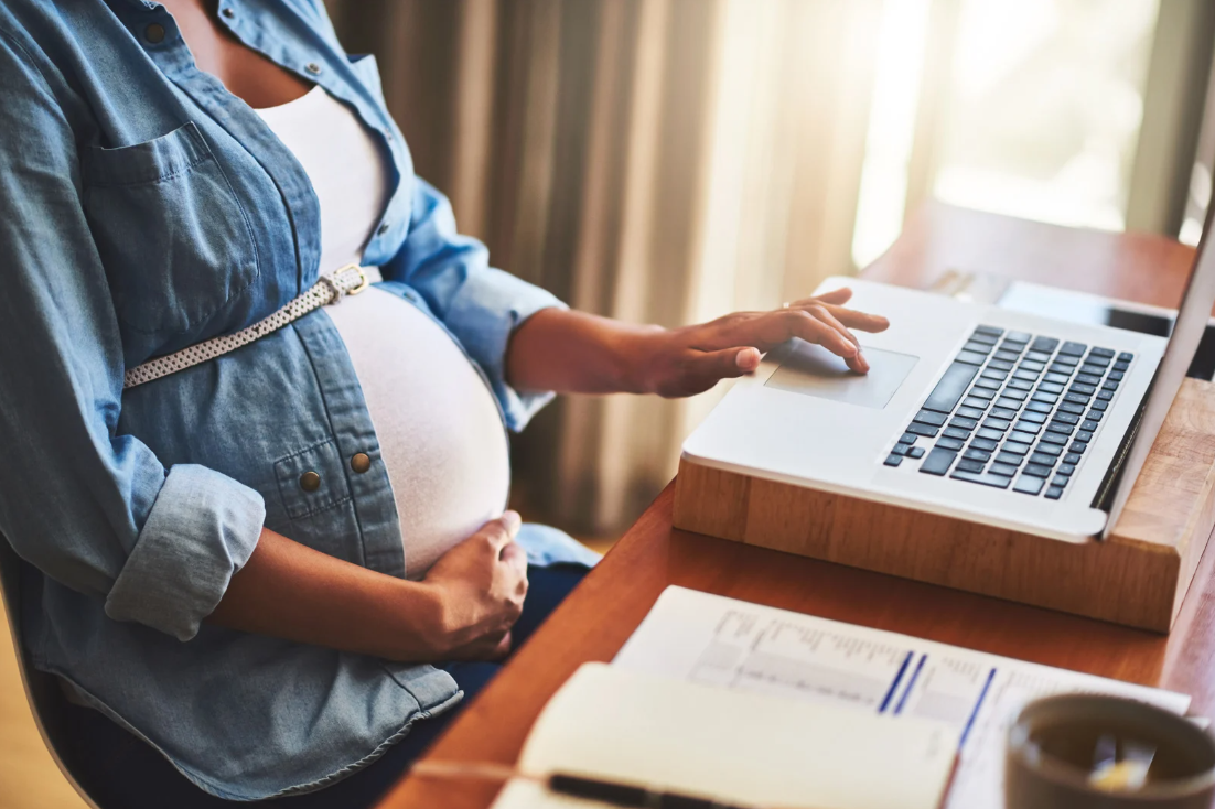 Pregnant Woman using a macbook