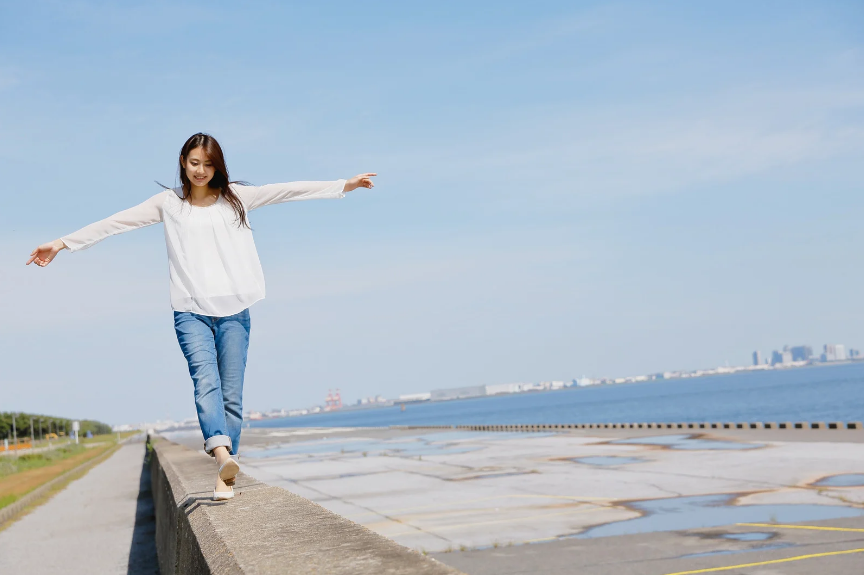 Woman balancing on beach wall