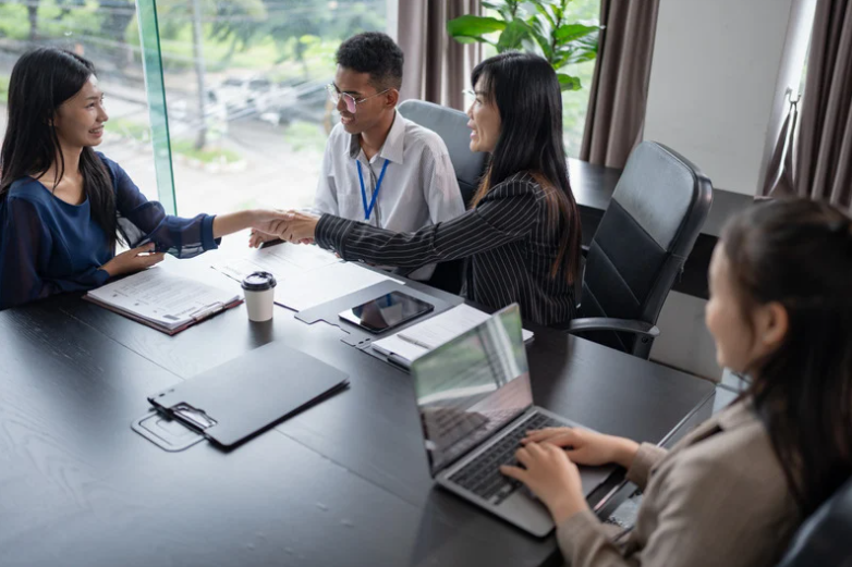 Happy employees talking around a table