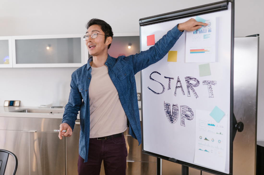 man next to white board