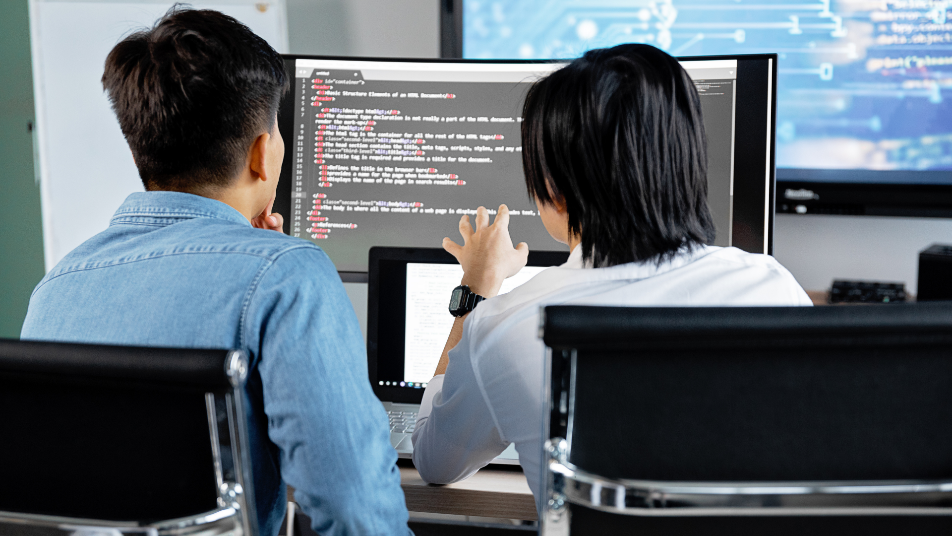 man and woman looking at computer