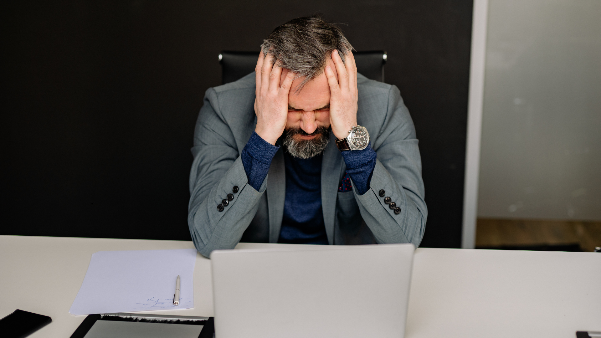 man with both hands on head